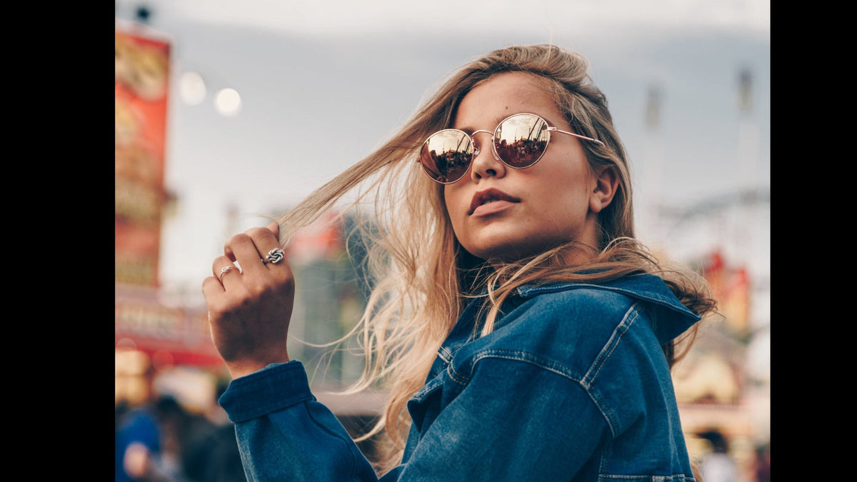 Woman wearing a denim jacket and sunglasses in an urban setting